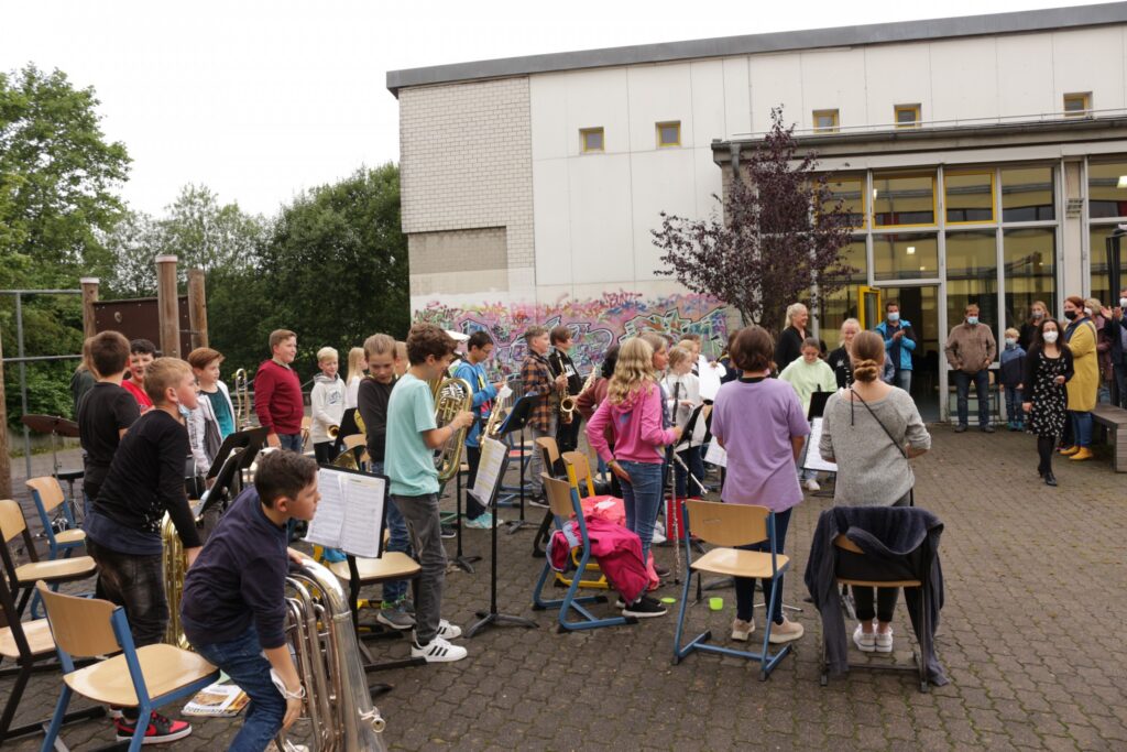 Schüler spielen in einer Gruppe im Freien Musikinstrumente.