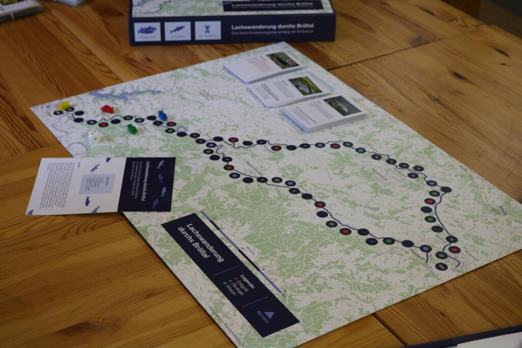 Karte mit einem Wanderweg und Informationsmaterial auf einem Holztisch.