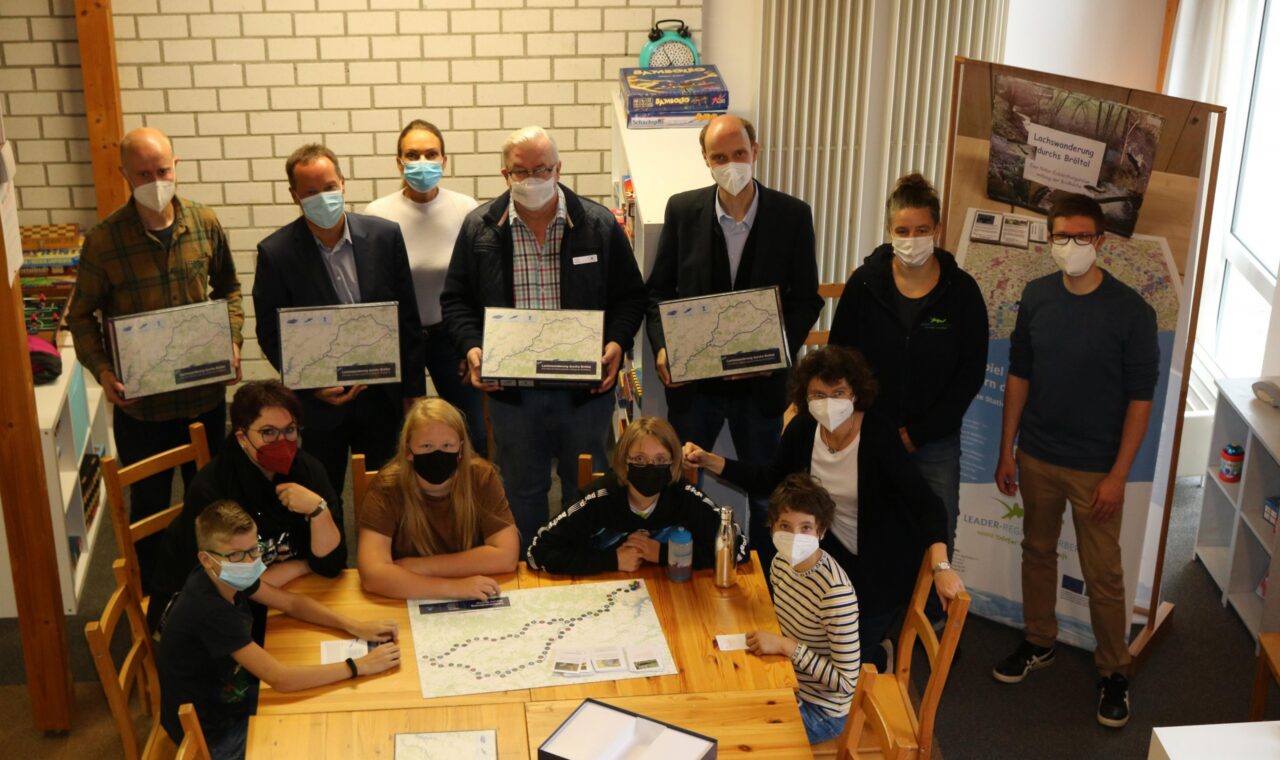 Gruppe von Personen in einem Raum, alle tragen Masken und halten Plakate.
