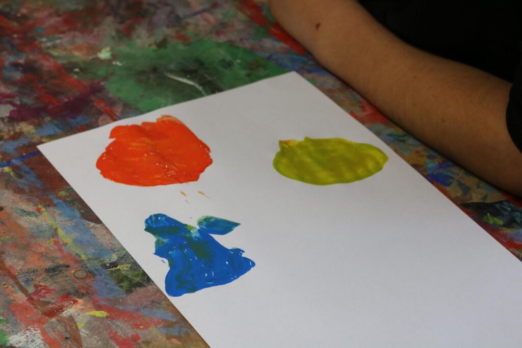 Bunt bemalte Farbkleckse auf einem weißen Blatt Papier.