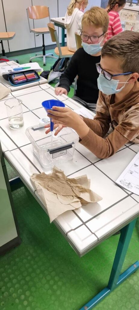 Schüler führen im Unterricht Experimente mit Reagenzgläsern durch.