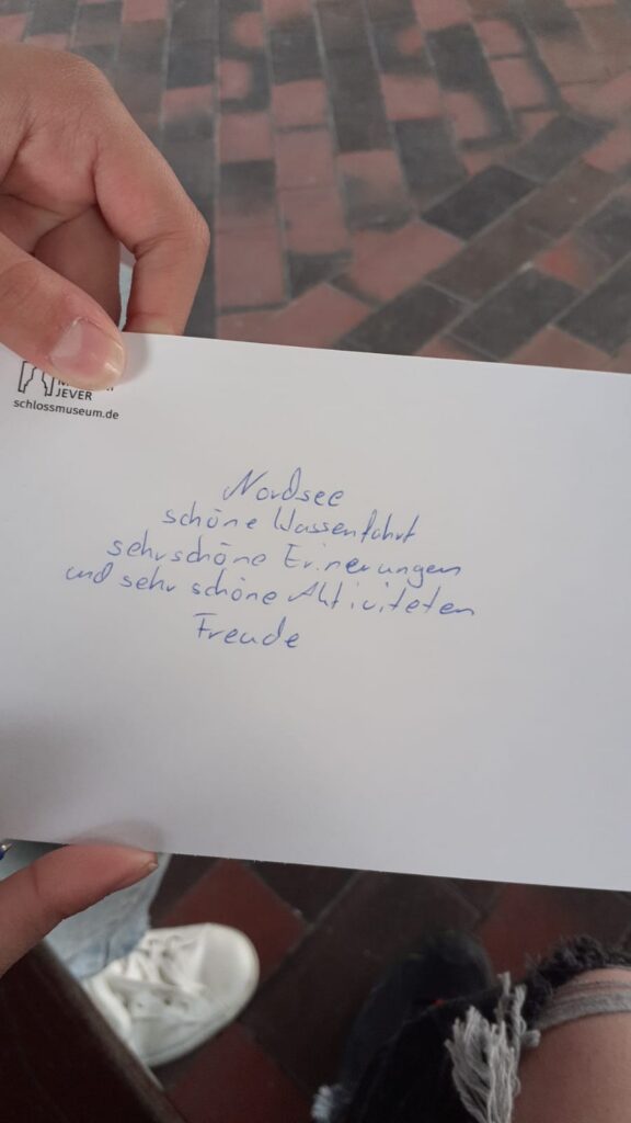 Eine Hand hält eine beschriebene Karte.