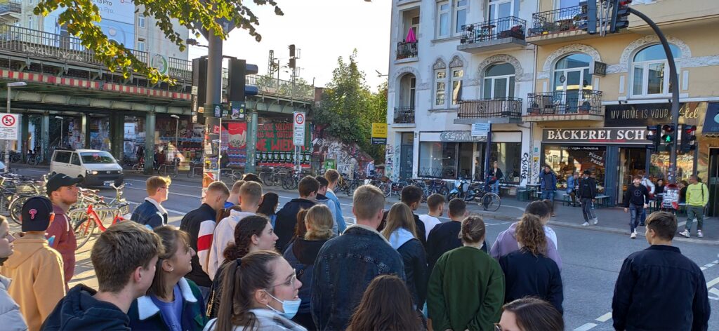Menschenmenge an einer Straßenecke, warten auf die Ampel.