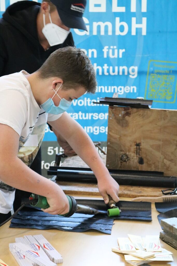 Schüler bei der Arbeit mit Werkstoffen in einer Werkstatt.
