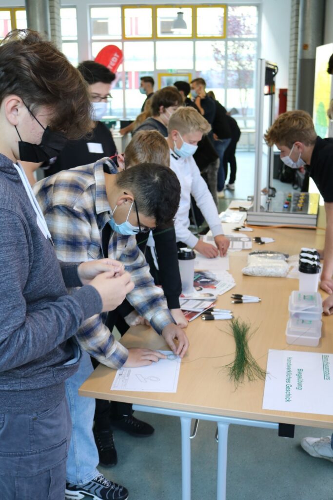 Schüler arbeiten an Tischen mit Materialien und Projekten zusammen.