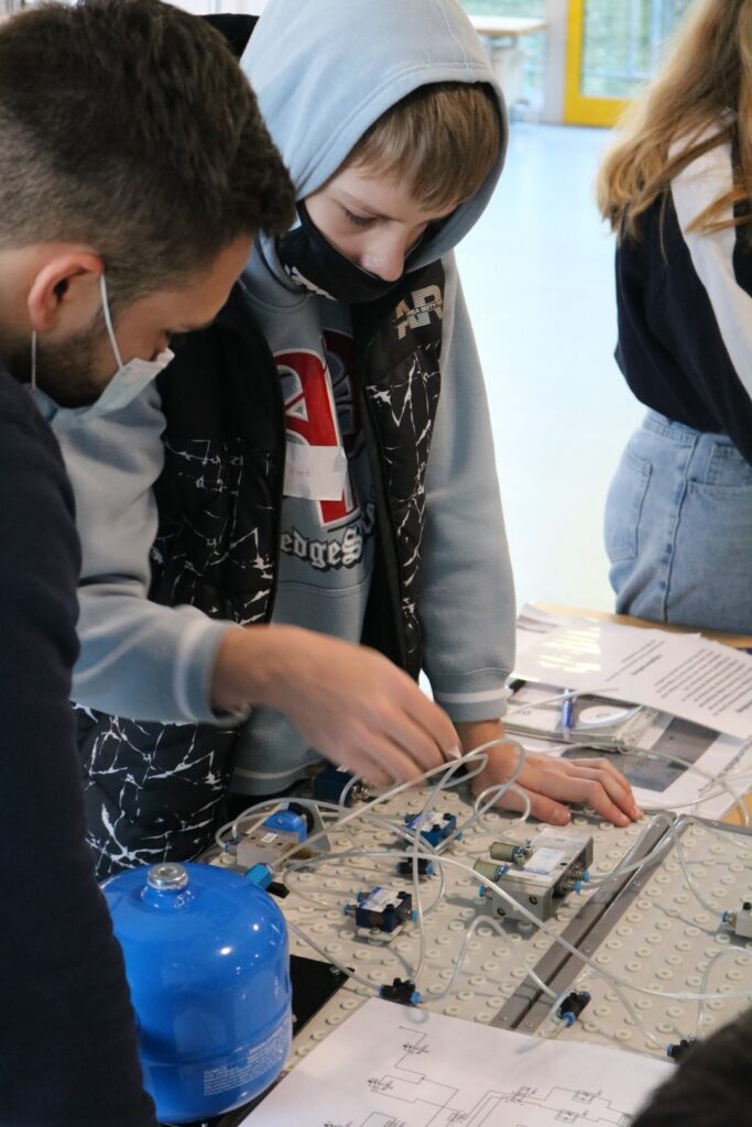 Schüler arbeitet an einem technischen Projekt mit Kabeln und Bauteilen.