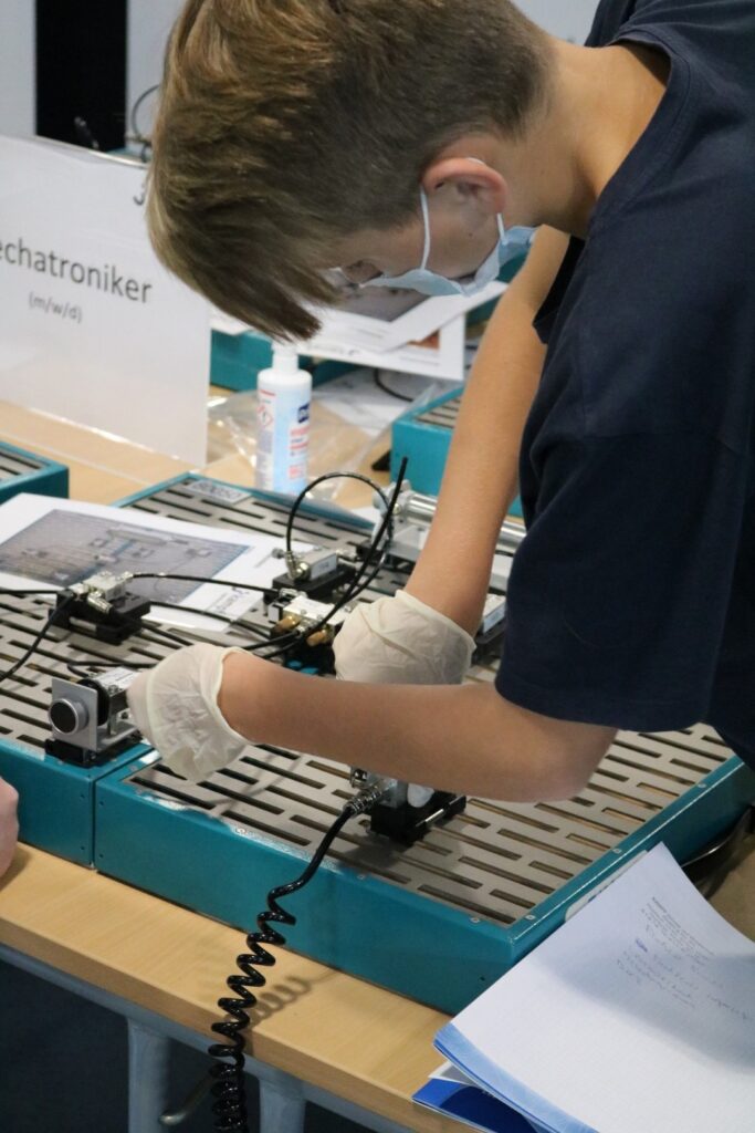 Schüler arbeitet an einem technischen Projekt an einem Tisch.