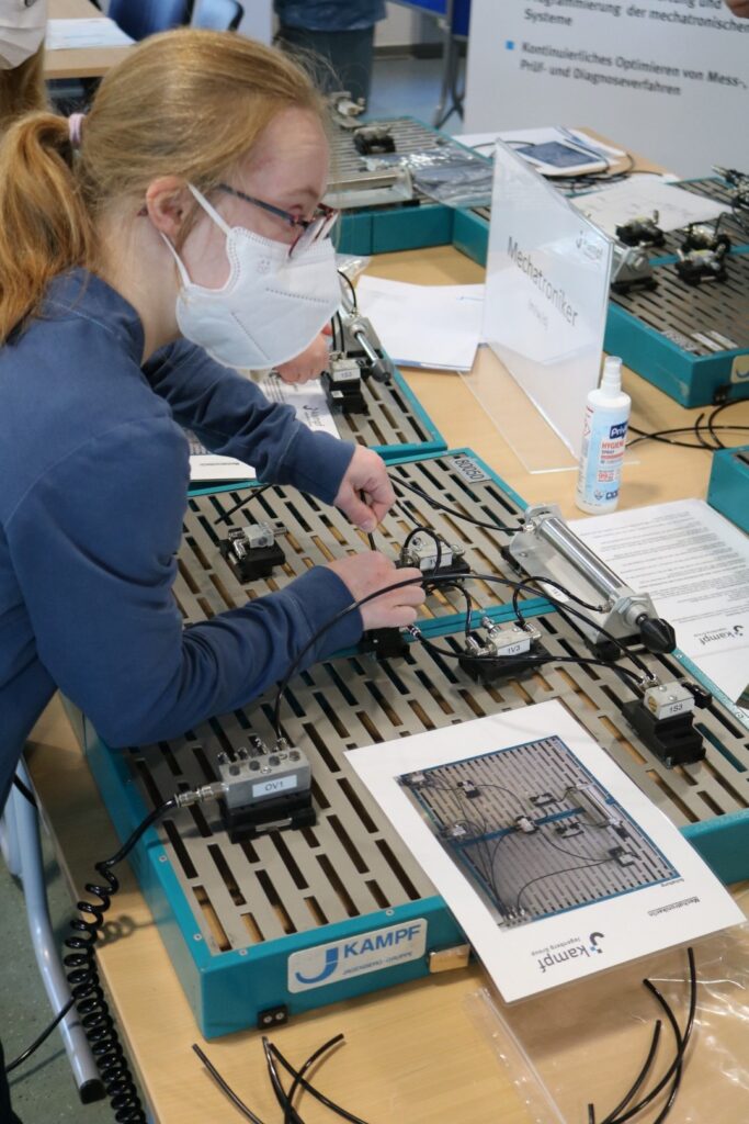 Schülerin arbeitet an einem technischen Experiment mit elektrischen Bauteilen.