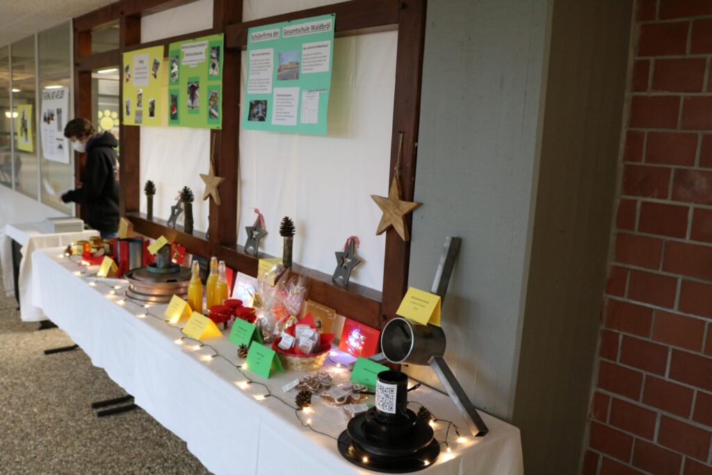 Ein Tisch mit Ausstellungsobjekten und dekorativen Elementen in einem Schulflur.