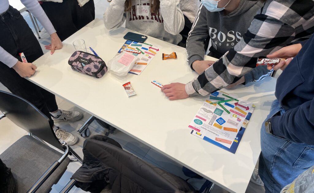 Schüler arbeiten gemeinsam an einem Tisch mit verschiedenen Materialien.