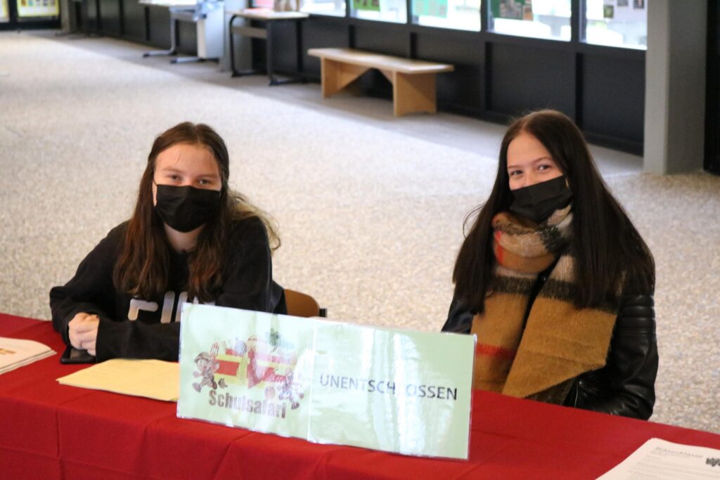 Zwei Schülerinnen sitzen an einem Tisch und tragen Masken.
