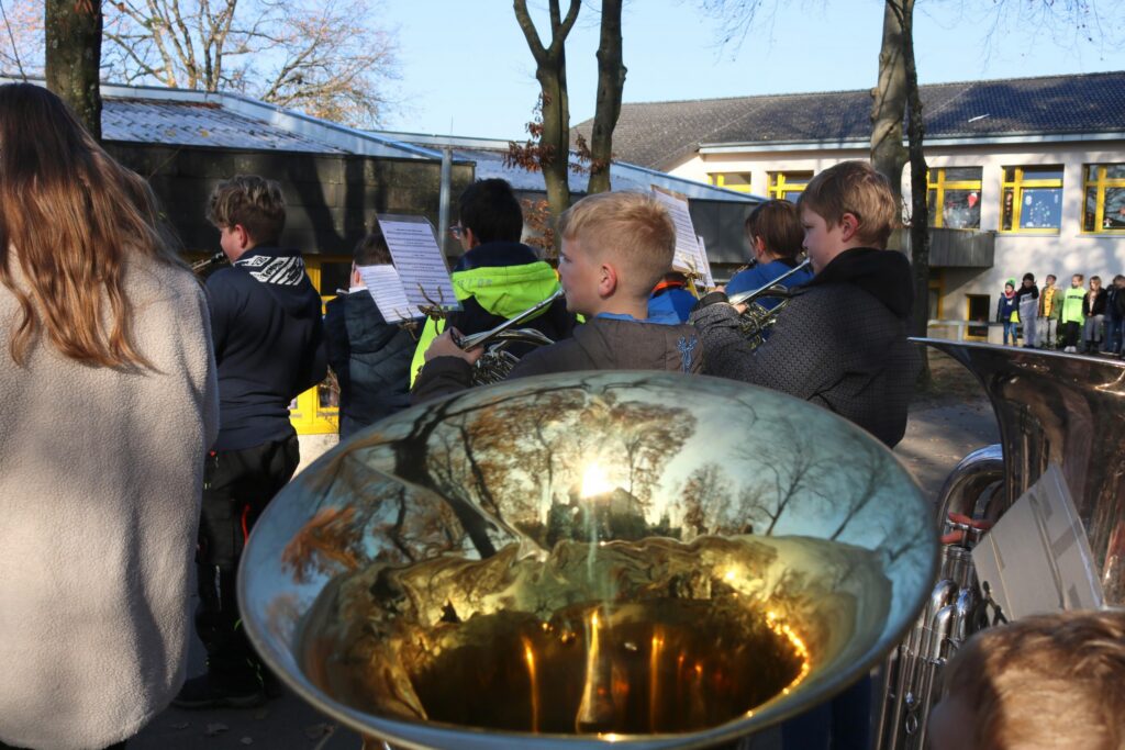 Schüler mit Musikinstrumenten bei einem Auftritt draußen.