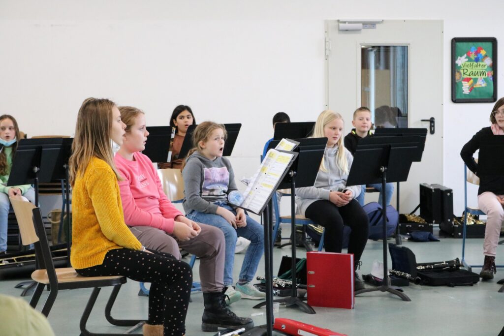 Schülerinnen sitzen in einem Musikraum und üben gemeinsam.