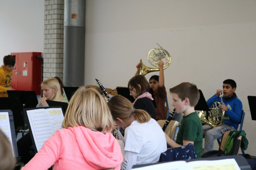 Schüler spielen in einem Musikraum verschiedene Instrumente.