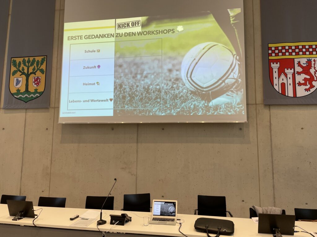Raum mit Präsentation über Workshops und vorbereitendem Material.