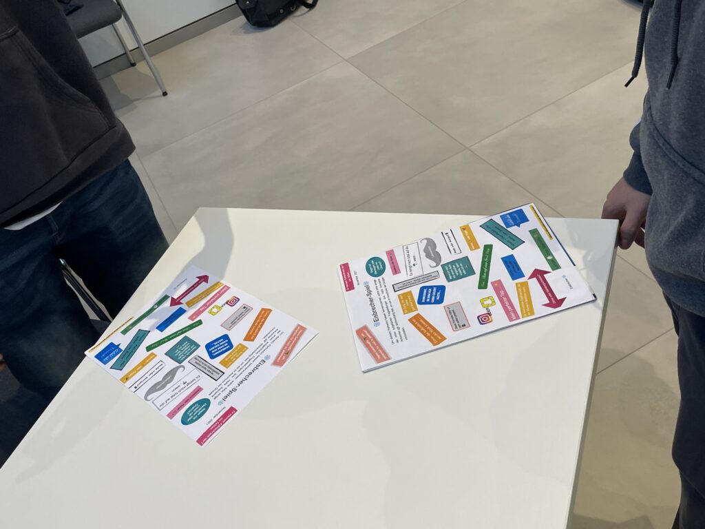 Zwei Arbeitsblätter mit bunten Grafiken auf einem Tisch.