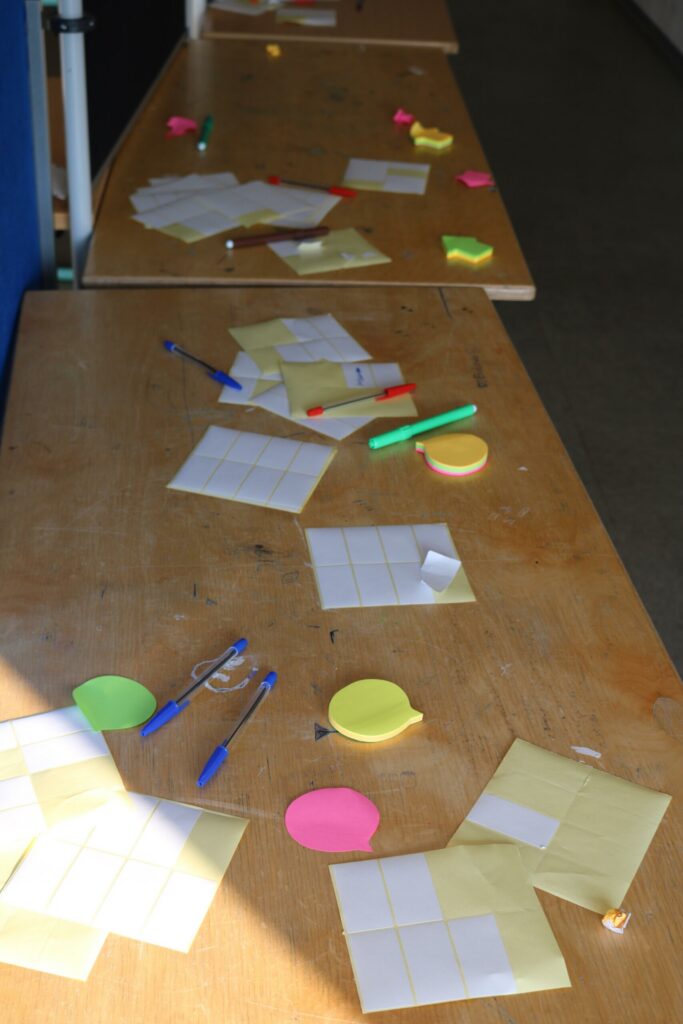 Arbeitsplätze mit Post-its, Stiften und bunten Notizen.
