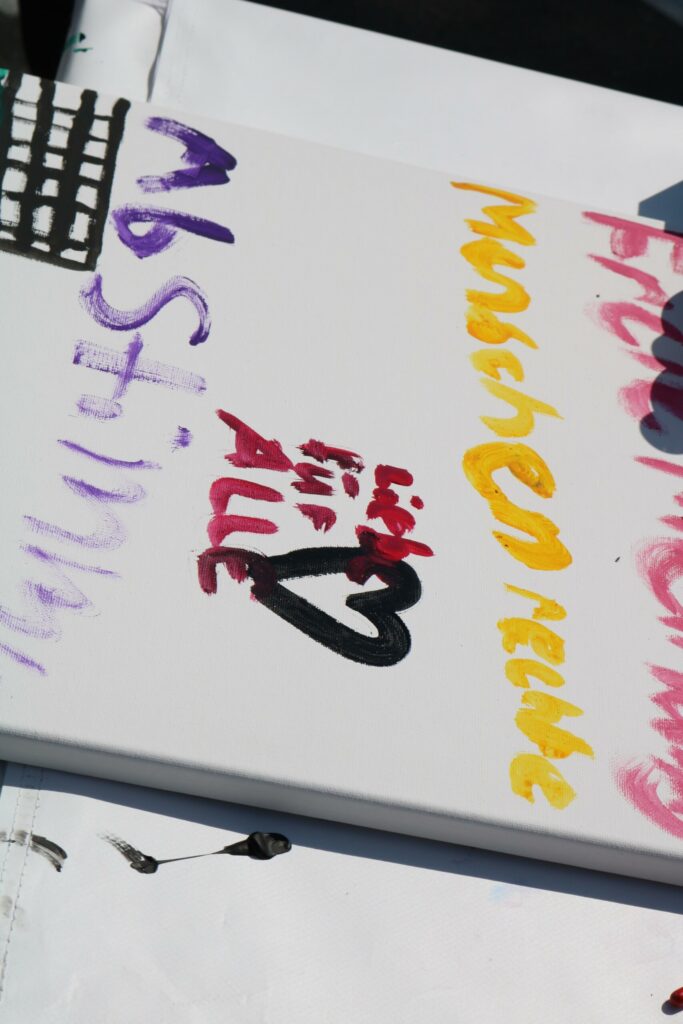 Bunte Malereien und Schriftzüge auf einer weißen Leinwand.