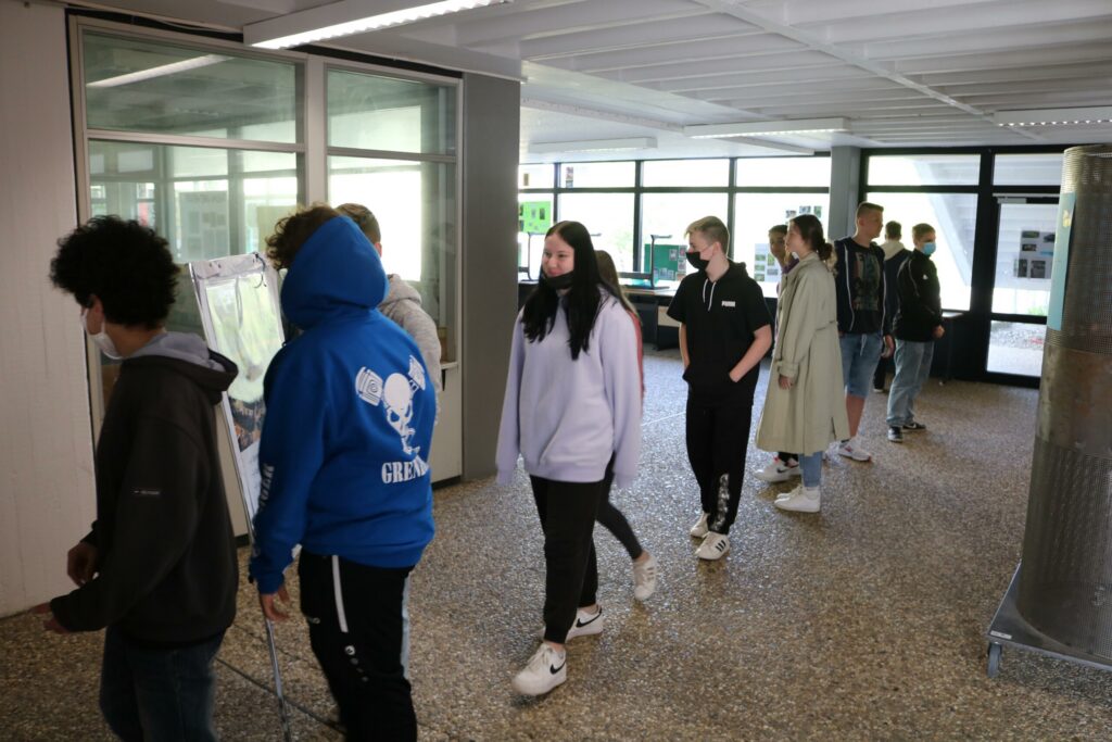 Schüler gehen in einer Schulhalle in einer Reihe entlang.