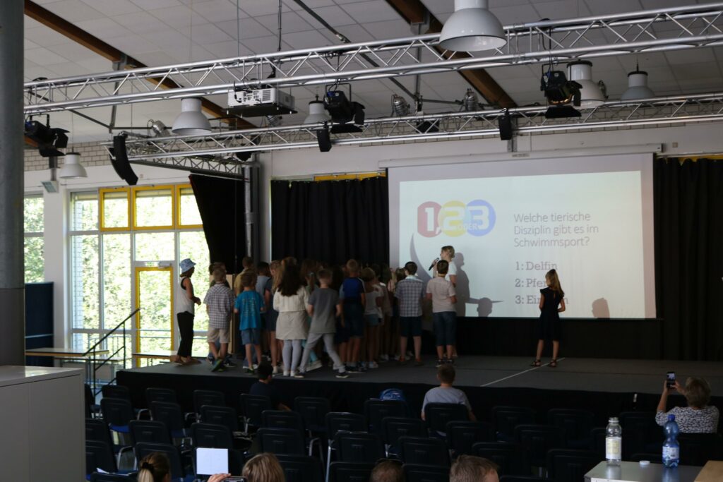 Schüler auf der Bühne während einer Veranstaltung in der Aula.
