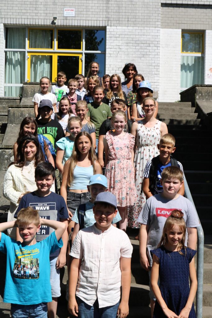 Gruppenfoto von Schülern auf einer Treppe vor einer Schule.