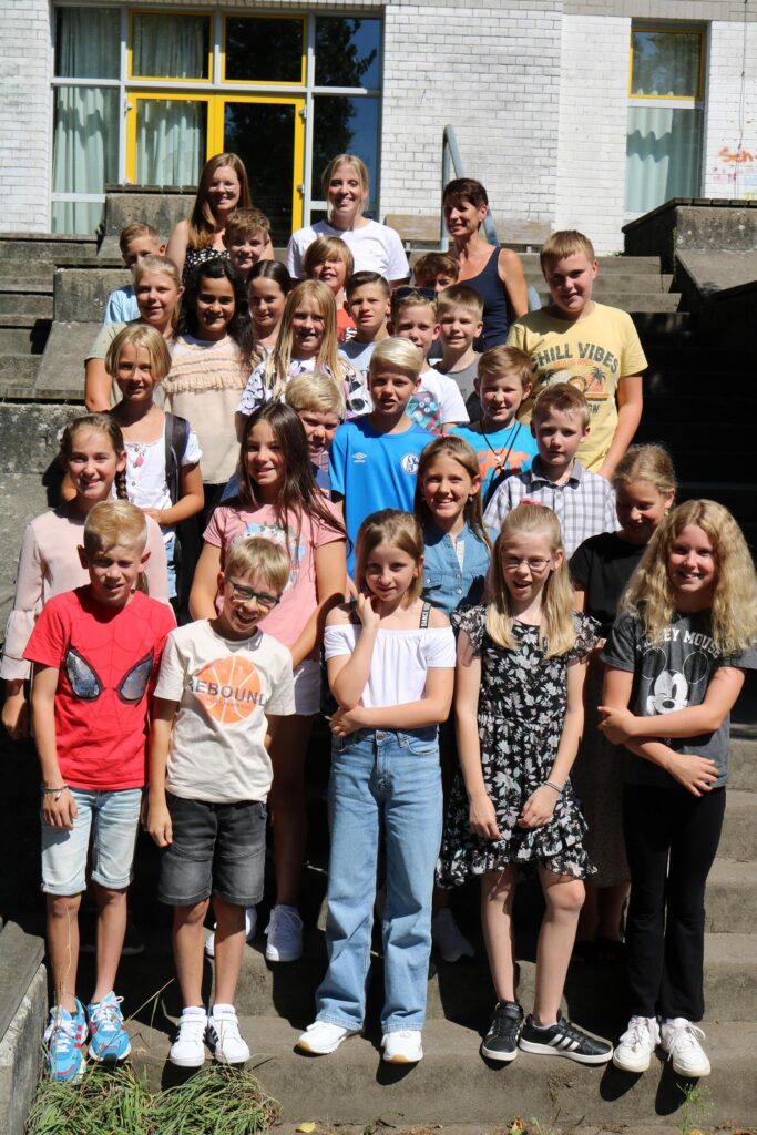 Gruppenfoto von Schülern und Lehrern vor einem Gebäude.