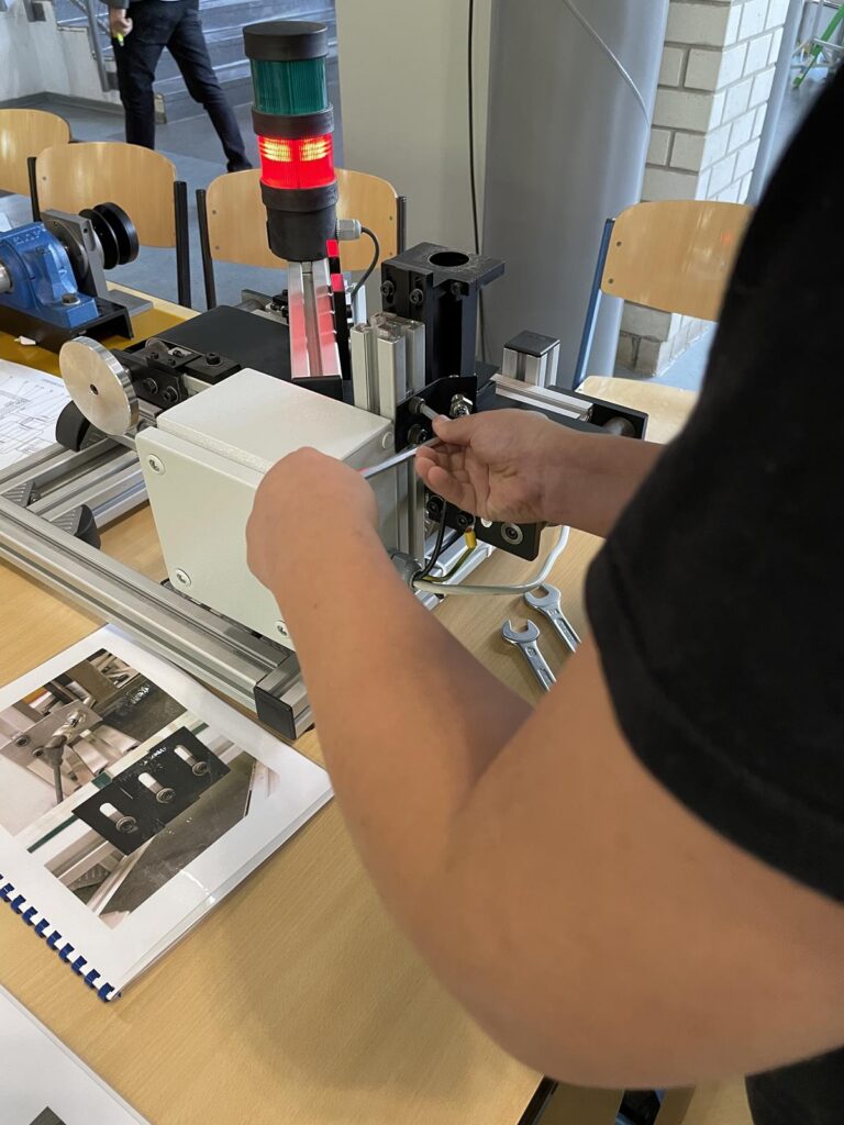Eine Person arbeitet an einer Maschine, um ein Kabel zu befestigen.
