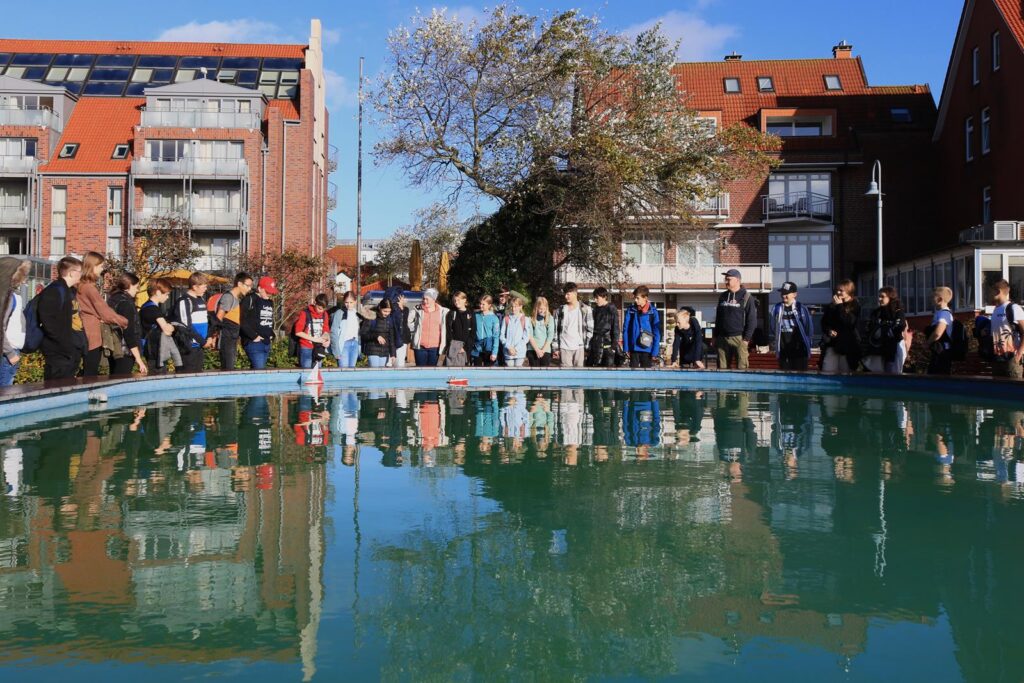 Schüler stehen am Rand eines Beckens und beobachten das Wasser.
