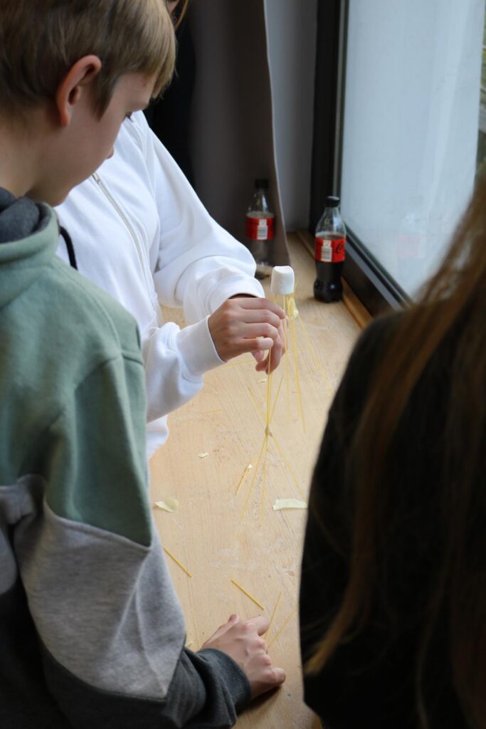 Schüler führen ein Experiment mit Spaghetti und Flüssigkeiten durch.