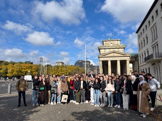 Gruppe von Schülern vor dem Brandenburger Tor bei sonnigem Wetter.