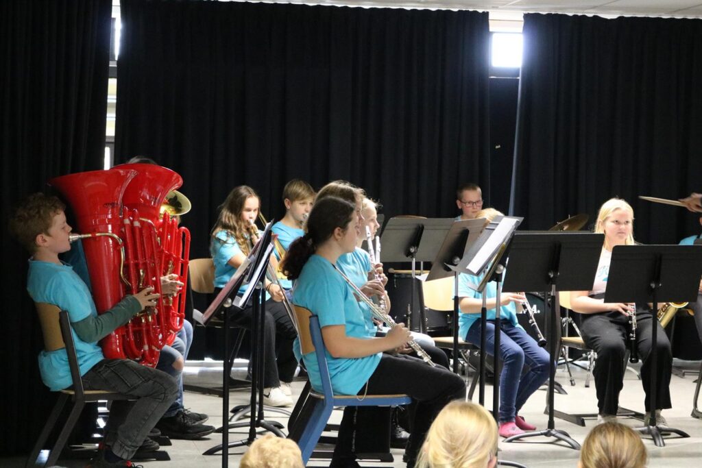 Schüler spielen in einem Musikensemble mit verschiedenen Instrumenten.