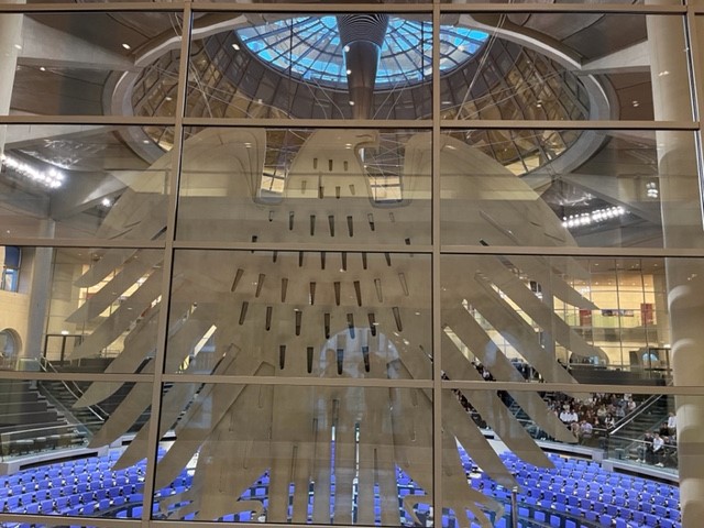 Foyer mit gläserner Wand und sichtbar angeordneten Sitzreihen.