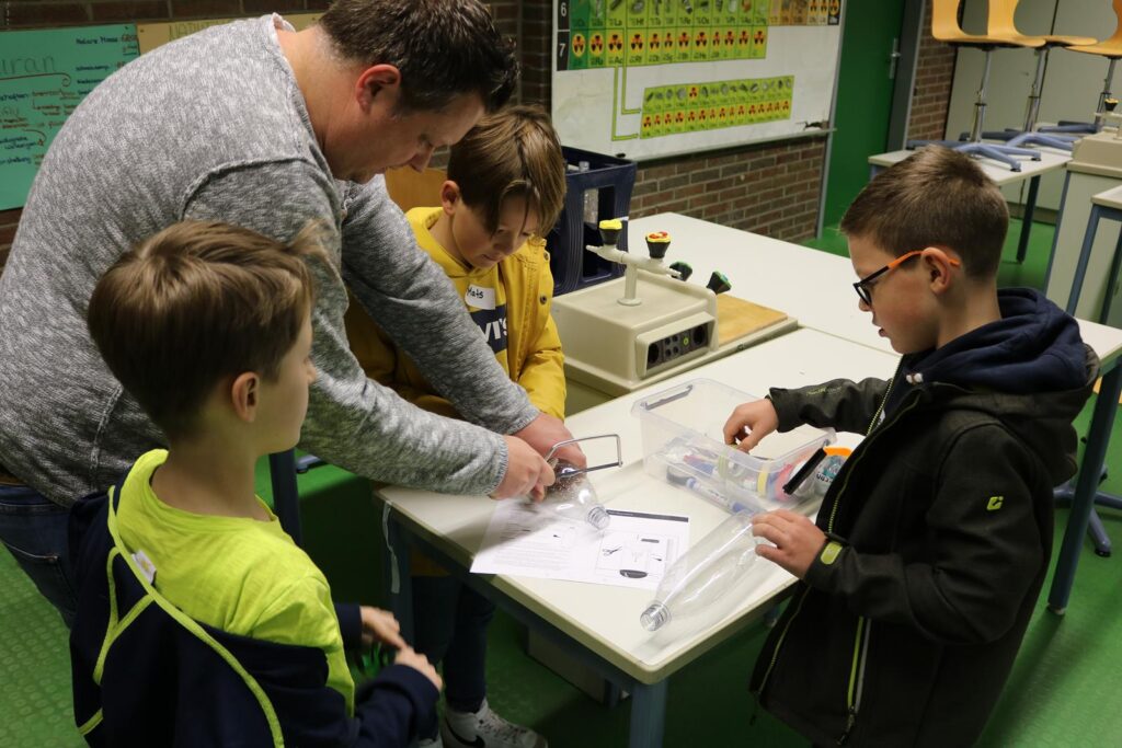 Vier Personen arbeiten an einem Tisch mit Materialien und Forschungsunterlagen.