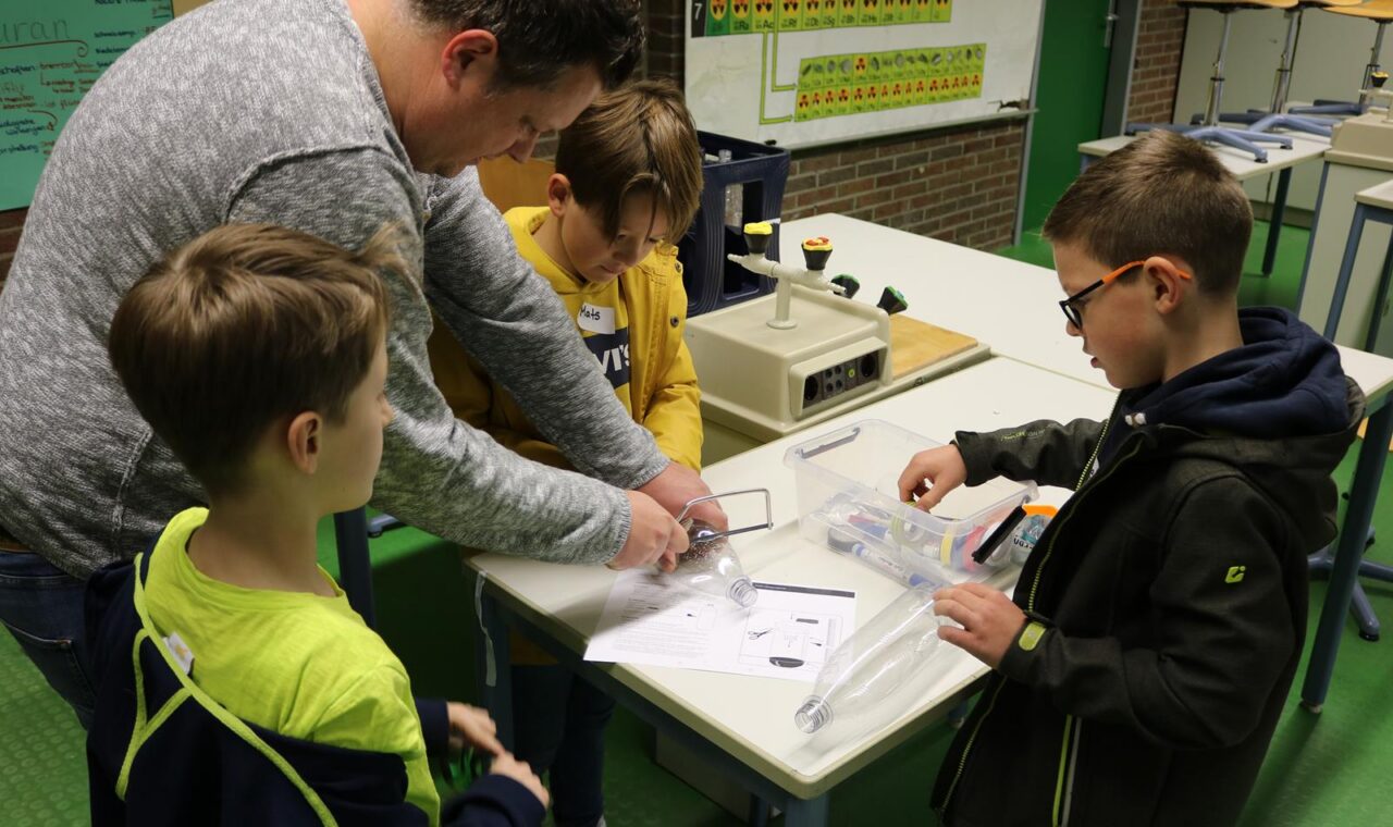 Vier Personen arbeiten an einem Tisch mit Materialien und Forschungsunterlagen.