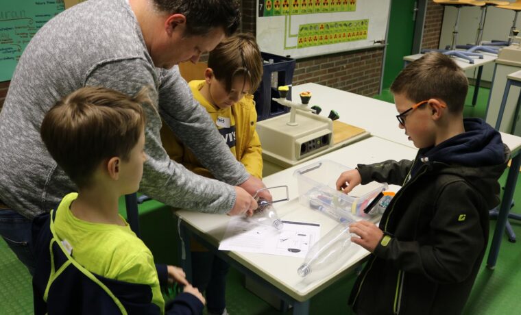 Vier Personen arbeiten an einem Tisch mit Materialien und Forschungsunterlagen.