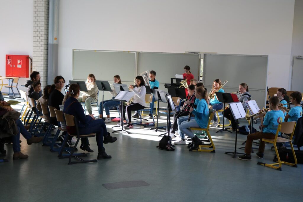 Schülergruppe beim Musizieren in einem hellen Raum.