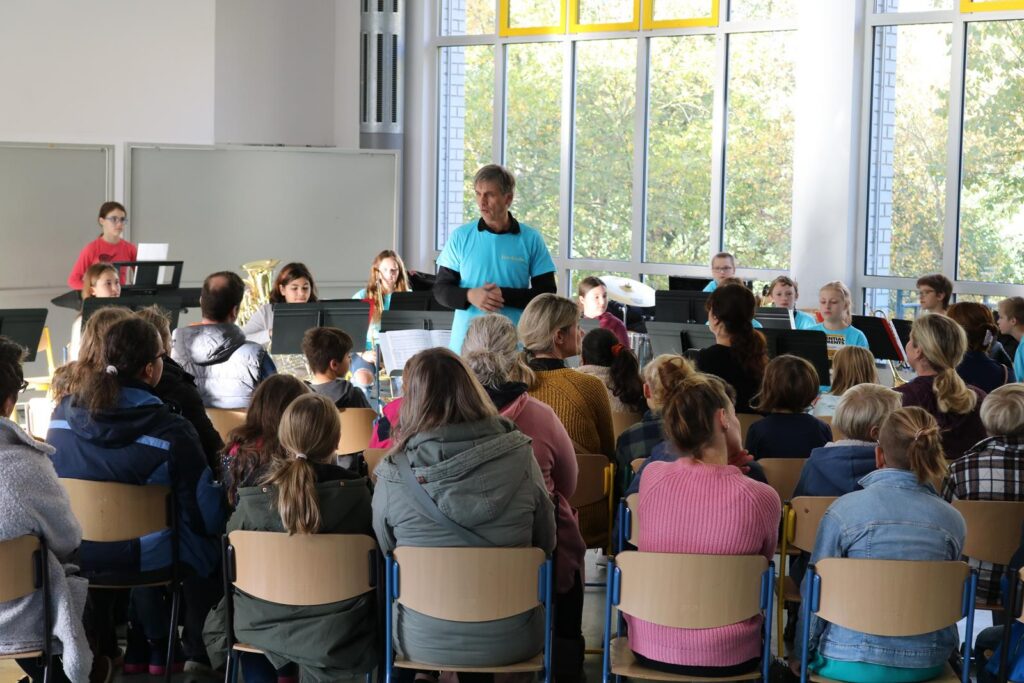 Schüler und Lehrer bei einem Konzert in einem Klassenraum.