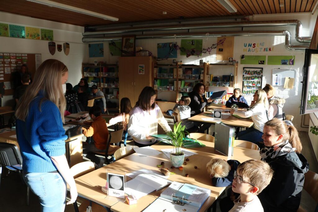Lehrer und Schüler arbeiten in einem hellen Klassenraum zusammen.