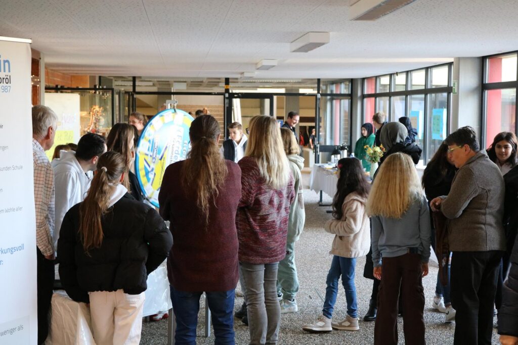 Gruppierung von Schülern und Erwachsenen in einem Schulgebäude während einer Veranstaltung.