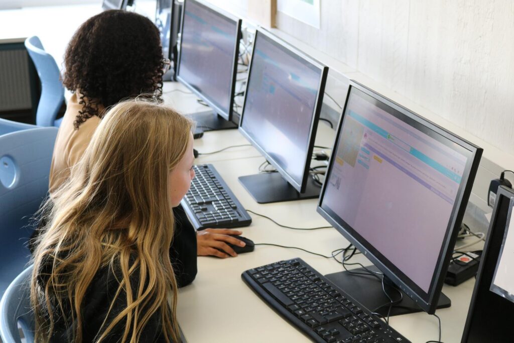 Schülerinnen arbeiten an Computern in einem Klassenzimmer.
