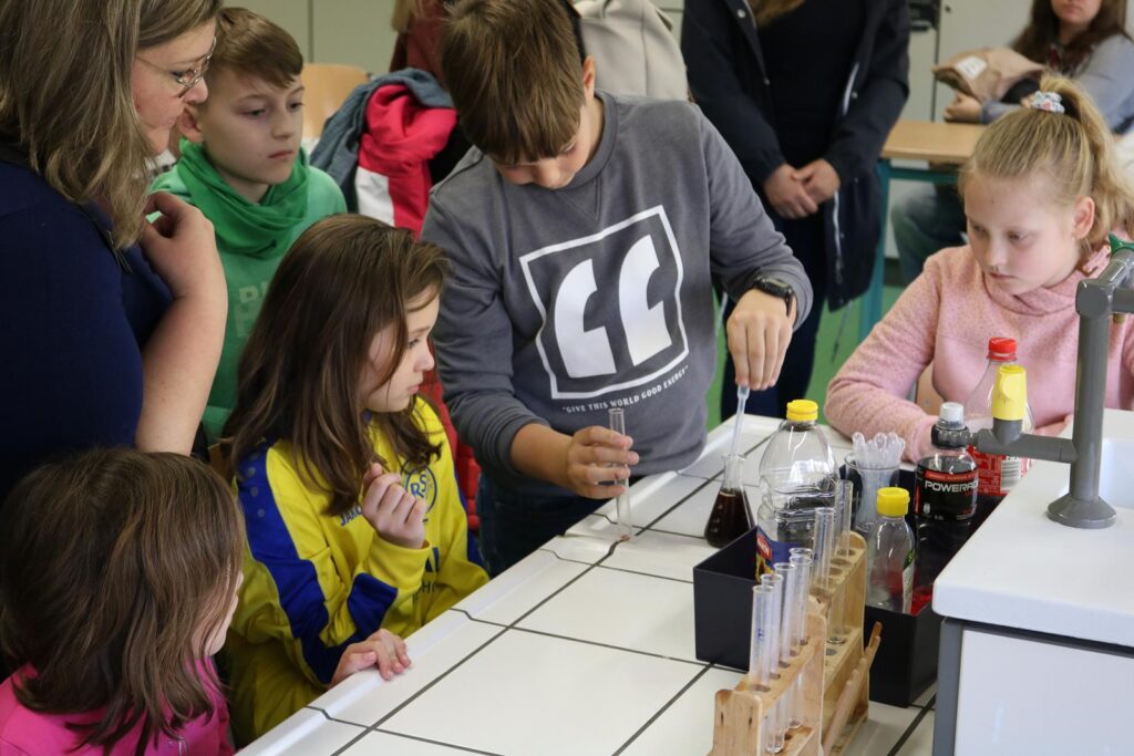 Schüler führen ein Experiment mit Flüssigkeiten in einem Klassenzimmer durch.