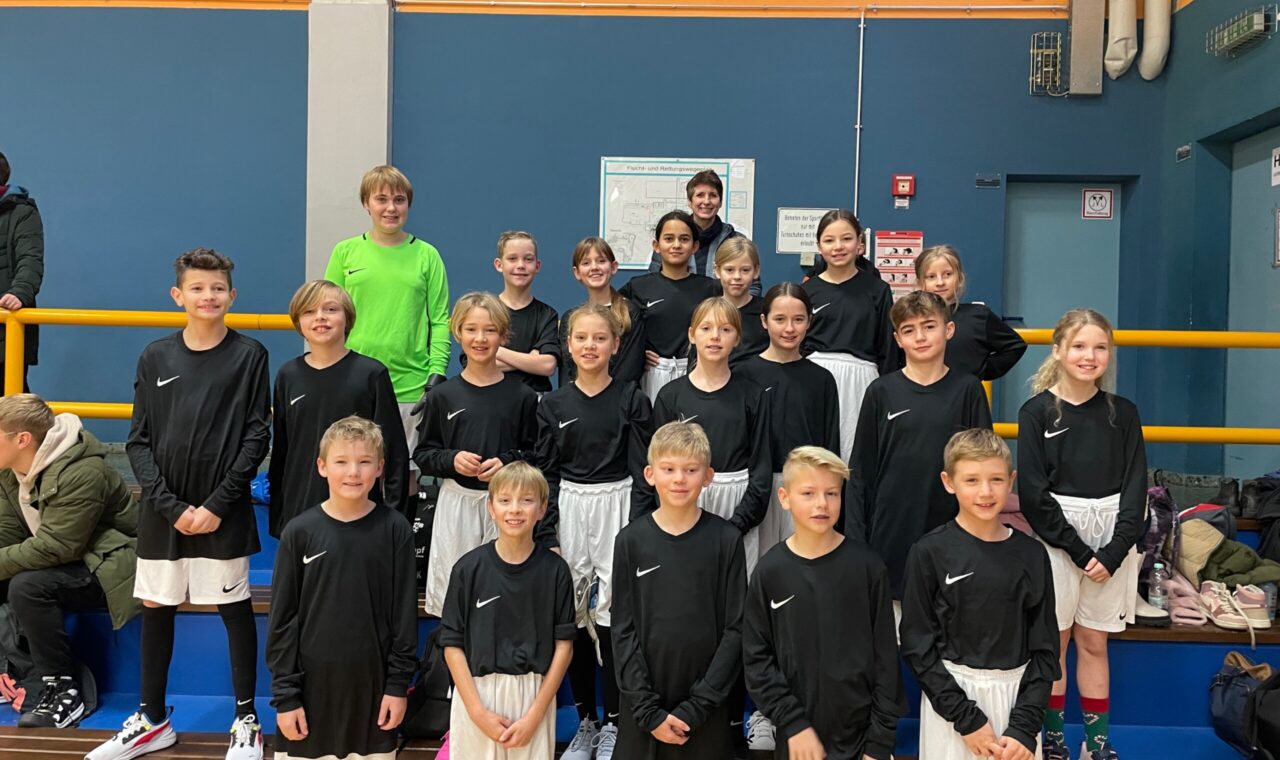 Gruppe von Kindern in Sportkleidung, die lächeln und posieren.