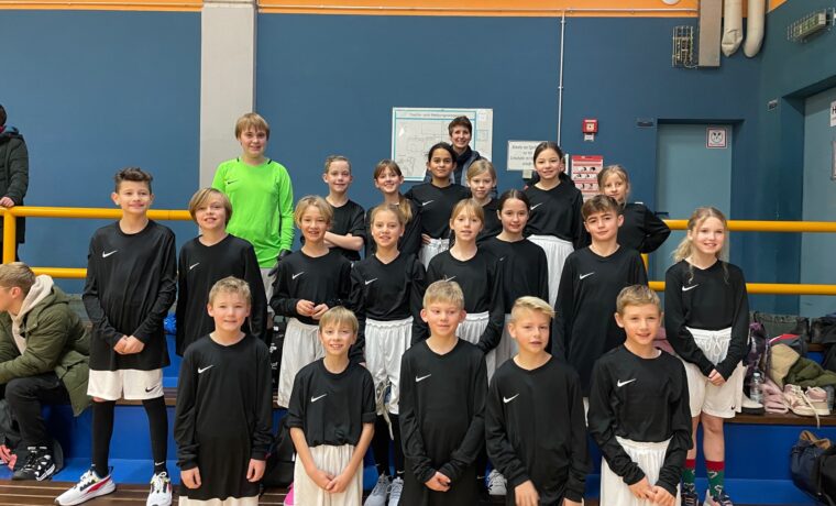 Gruppe von Kindern in Sportkleidung, die lächeln und posieren.