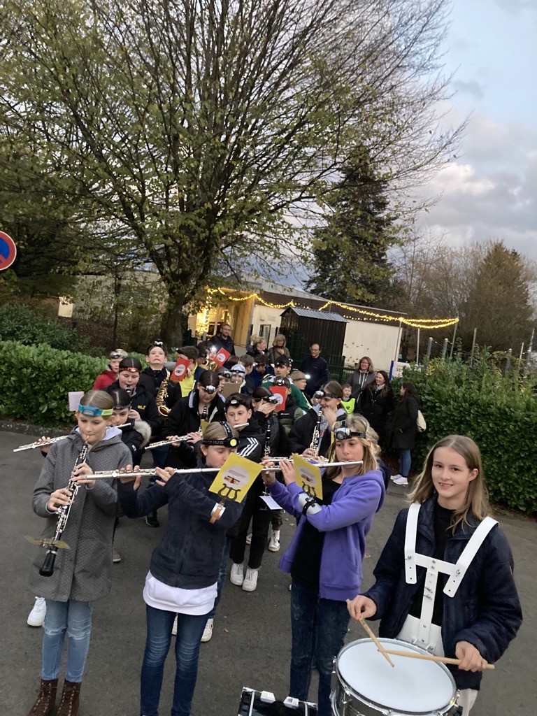 Schüler spielen gemeinsam in einer Blaskapelle im Freien.