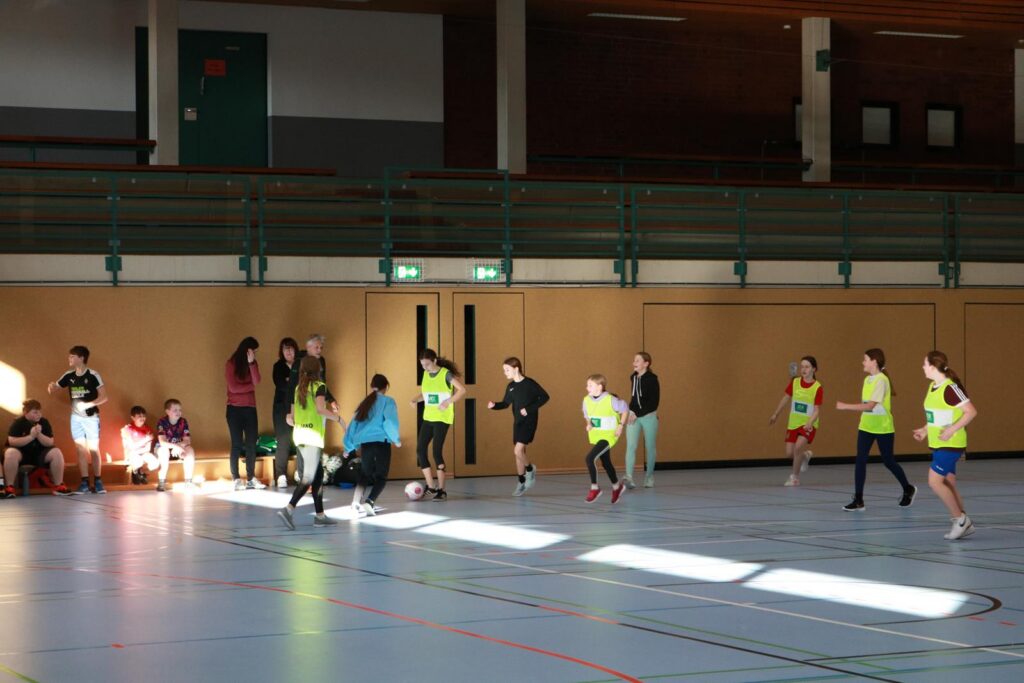 Schüler spielen in der Turnhalle ein Bewegungsspiel.
