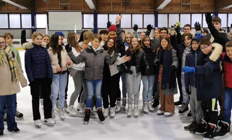Gruppe von Jugendlichen und Erwachsenen auf einer Eisbahn, alle in Schlittschuhen.