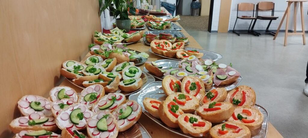 Bunte belegte Brötchen auf mehreren Platten, dekoriert mit Gemüse.