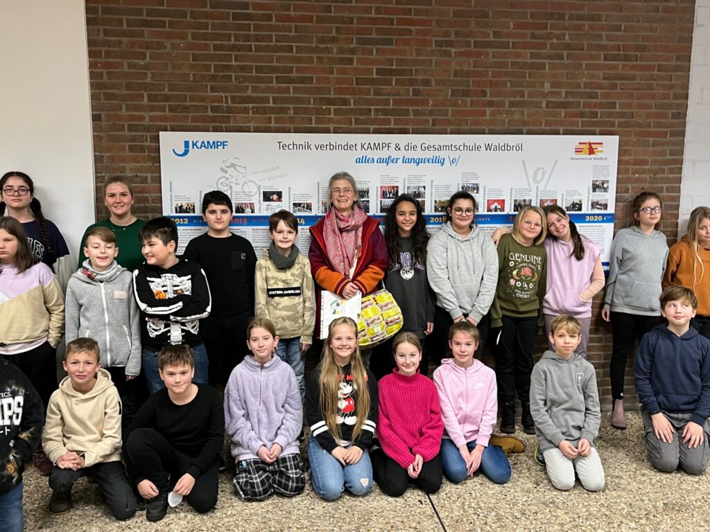 Gruppenfoto von Schülern und Lehrern vor einer Wandtafel in der Schule.