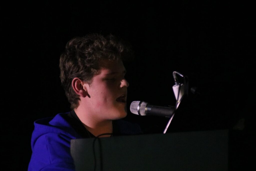 Ein junger Musiker singt und spielt Klavier.