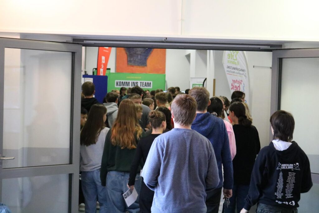 Schüler gehen in einen Raum, mehrere Köpfe sind zu sehen.